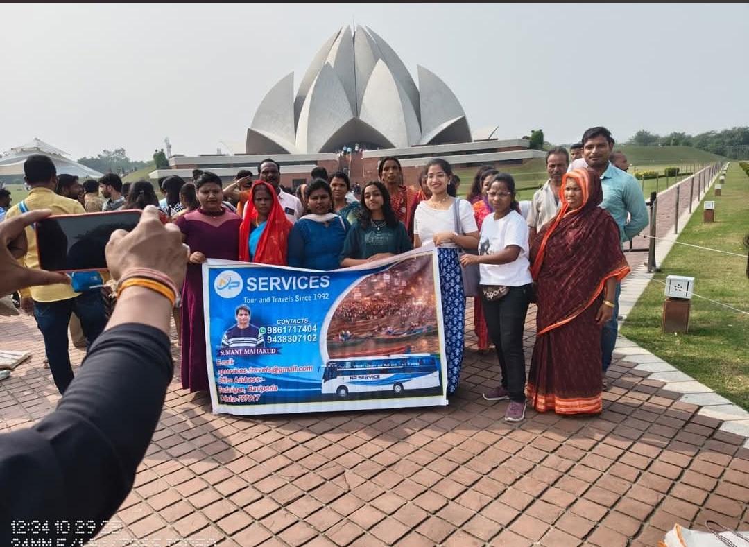 Travellers holding the NP Service banner in front of a lotus-shaped building